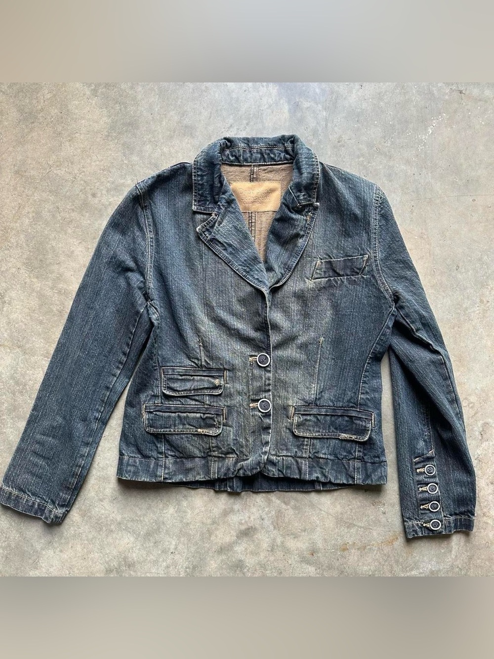 Y2K-style washed denim blazer with a two-button closure and distressed details